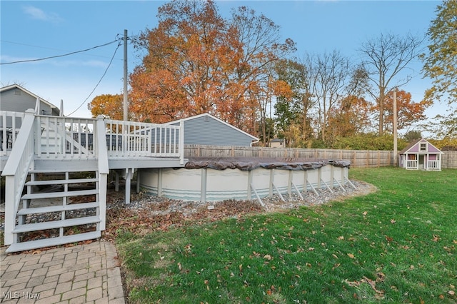 view of yard featuring a storage shed and a pool side deck