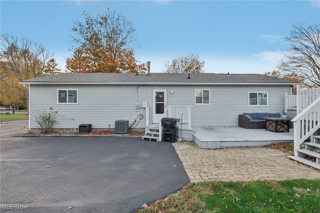 rear view of house with central air condition unit and a patio