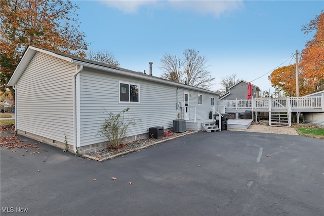 view of side of property with a wooden deck and central AC