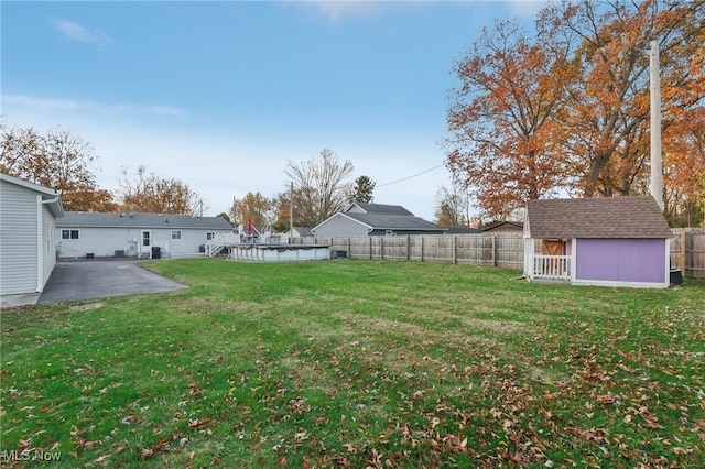 view of yard with a storage shed and a patio area