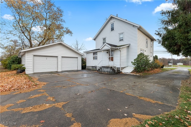 exterior space featuring a garage and an outbuilding