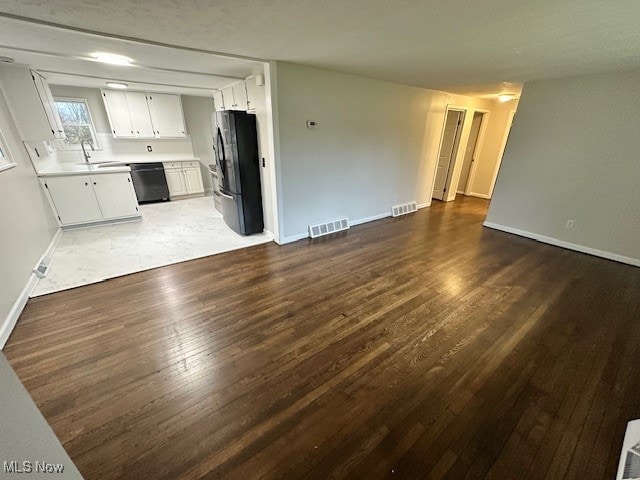 unfurnished living room featuring dark hardwood / wood-style floors, a textured ceiling, and sink