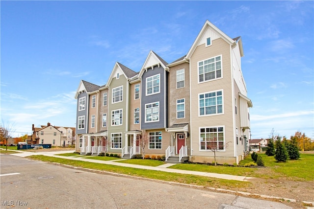 townhome / multi-family property featuring a front yard