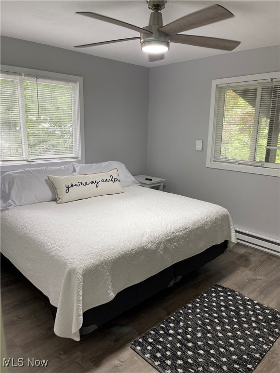 bedroom featuring hardwood / wood-style flooring, ceiling fan, and multiple windows