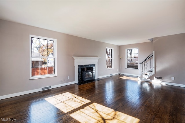 unfurnished living room with a high end fireplace and dark hardwood / wood-style flooring