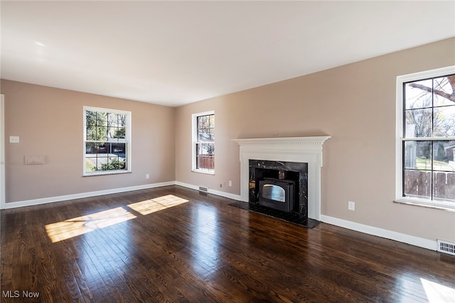 unfurnished living room with dark wood-type flooring and a premium fireplace