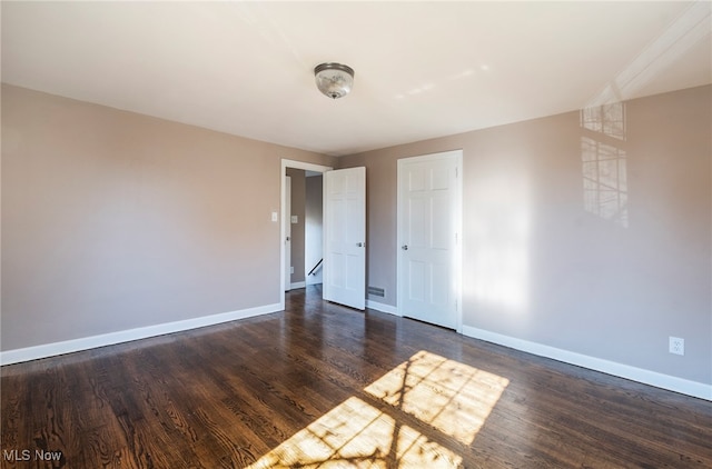 empty room featuring dark hardwood / wood-style flooring