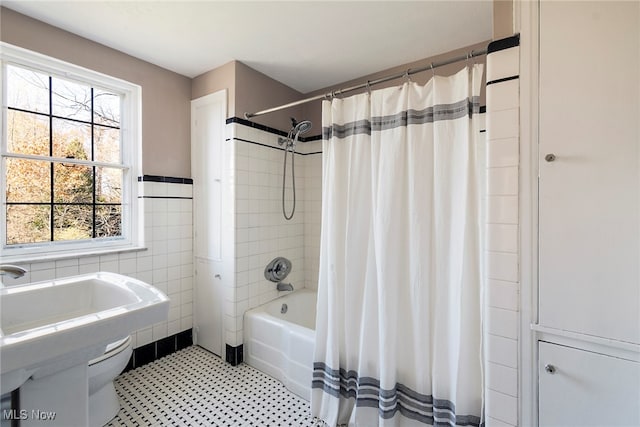 bathroom with shower / bath combo and tile walls