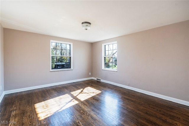 unfurnished room with dark wood-type flooring and a healthy amount of sunlight