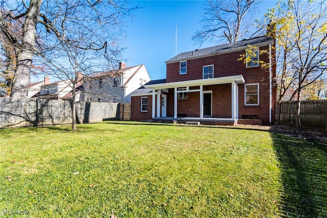 rear view of property featuring a yard