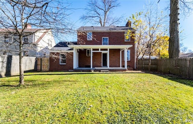 rear view of house featuring a lawn