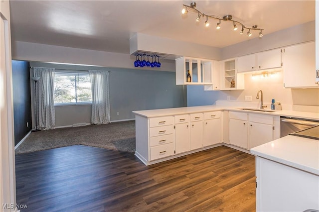 kitchen with white cabinets, dark hardwood / wood-style floors, stainless steel dishwasher, and sink