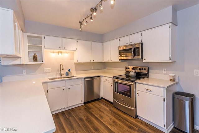 kitchen featuring sink, stainless steel appliances, white cabinetry, and dark hardwood / wood-style flooring