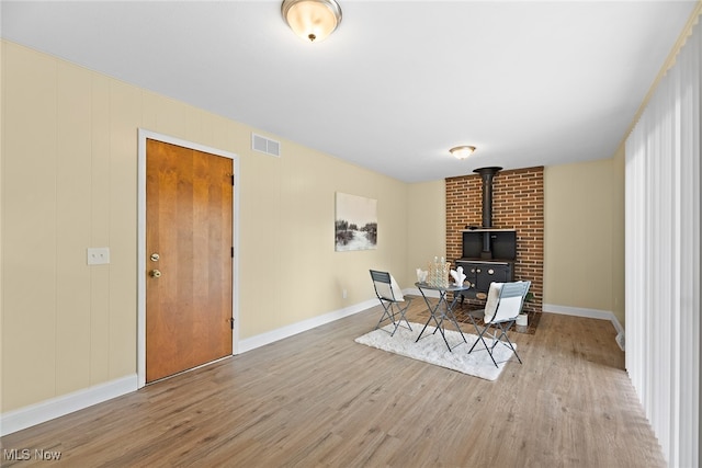 sitting room with light wood-type flooring and a wood stove