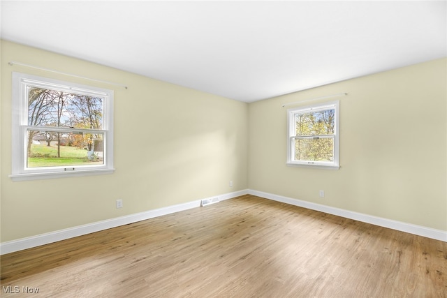 unfurnished room featuring light hardwood / wood-style floors and a wealth of natural light