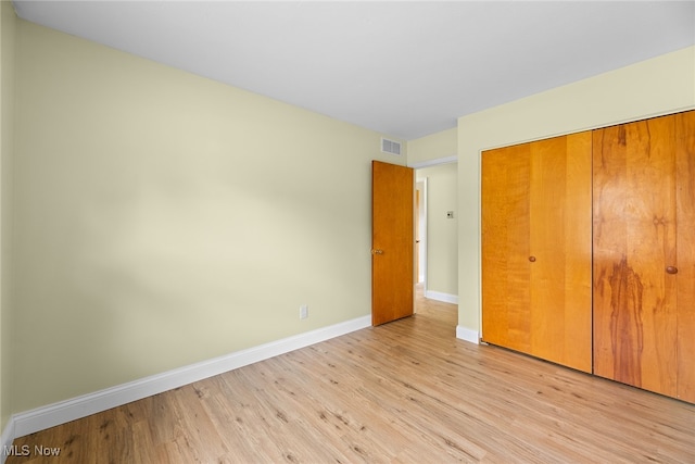 unfurnished bedroom featuring light hardwood / wood-style floors and a closet