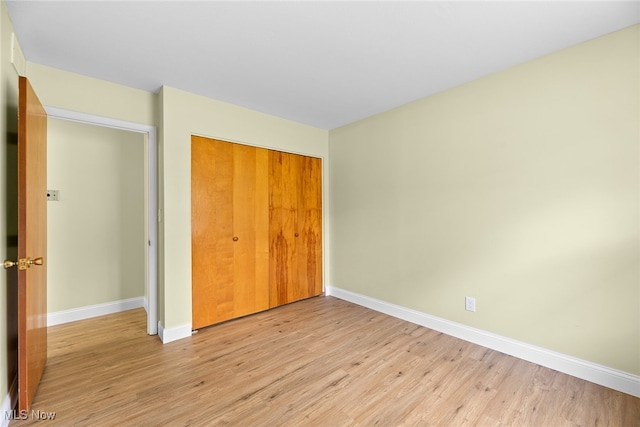 unfurnished bedroom with a closet and light hardwood / wood-style flooring