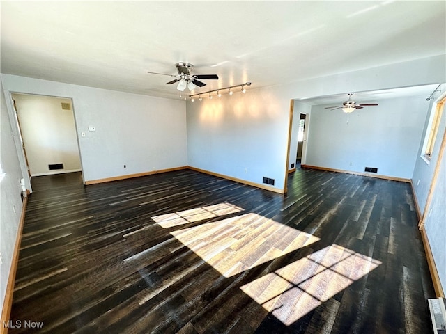 spare room with rail lighting, dark hardwood / wood-style floors, and ceiling fan