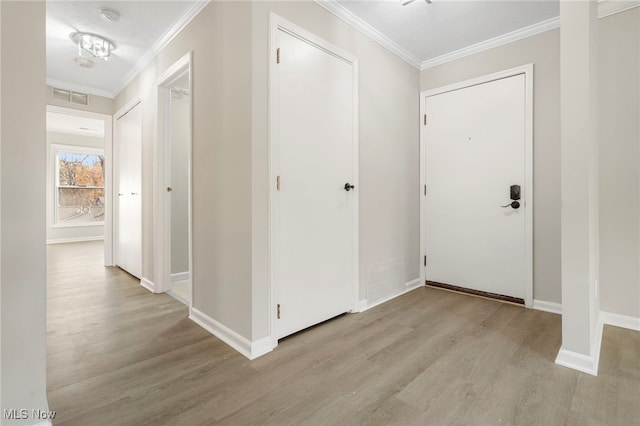 interior space featuring ornamental molding and light wood-type flooring