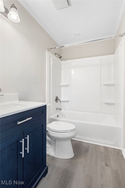 full bathroom featuring toilet, hardwood / wood-style floors,  shower combination, and crown molding