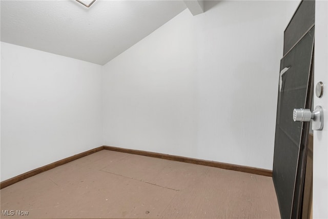 spare room featuring a textured ceiling and lofted ceiling