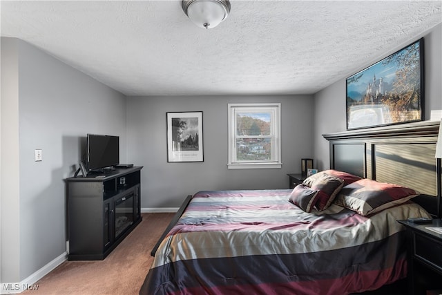 bedroom featuring a textured ceiling and dark carpet