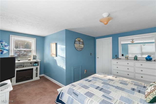 bedroom featuring light colored carpet, multiple windows, and a textured ceiling