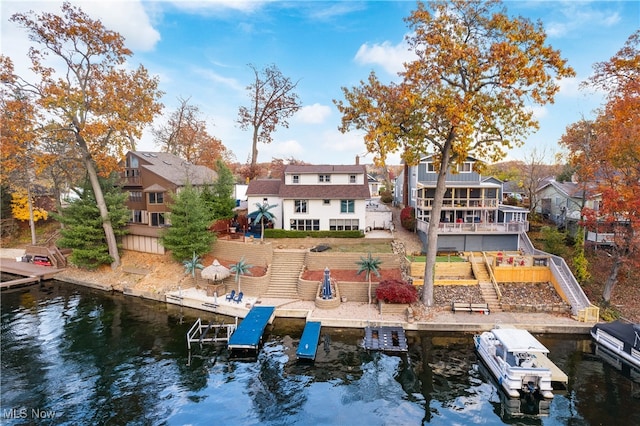 back of property with a deck with water view and a balcony