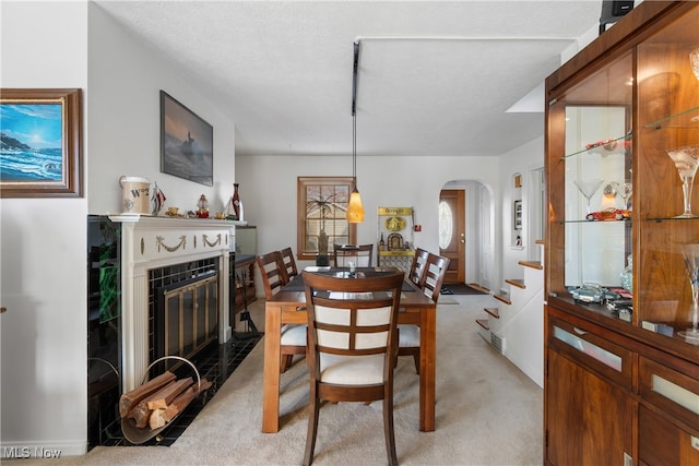 carpeted dining space with a textured ceiling