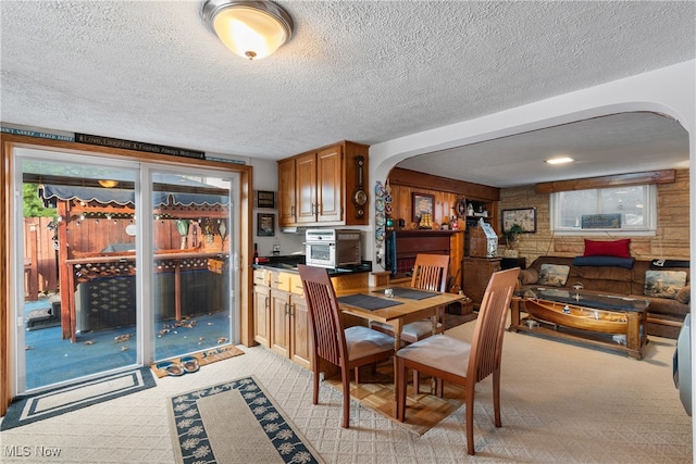 carpeted dining room with a textured ceiling