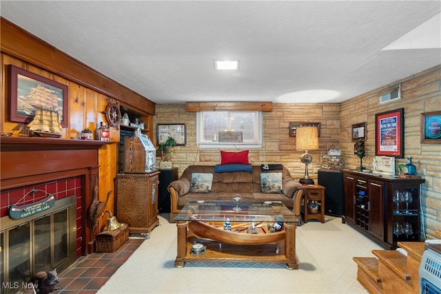 living room featuring a textured ceiling and a tile fireplace