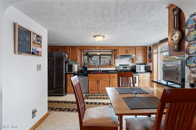 kitchen featuring a textured ceiling, appliances with stainless steel finishes, and sink