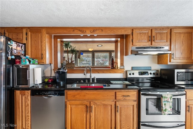 kitchen with a textured ceiling, appliances with stainless steel finishes, and sink