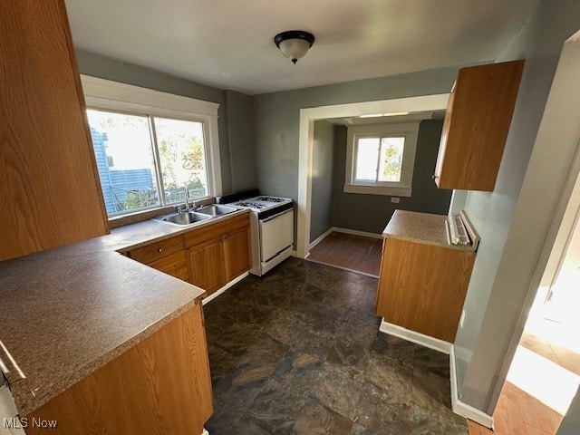 kitchen with kitchen peninsula, sink, and white stove