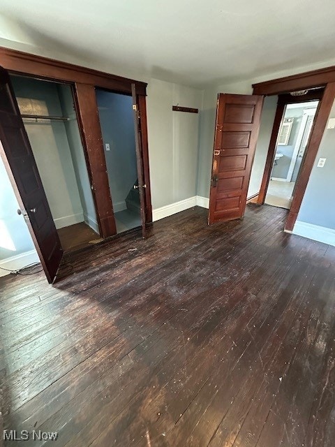 unfurnished bedroom featuring a closet and dark hardwood / wood-style flooring