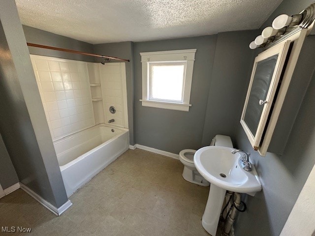 bathroom with shower / washtub combination, a textured ceiling, and toilet