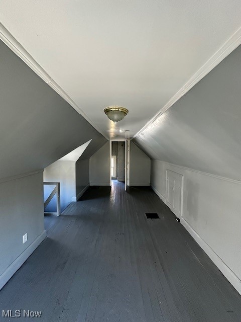 additional living space with dark hardwood / wood-style floors and vaulted ceiling