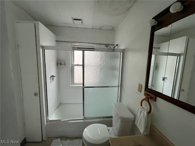 bathroom featuring enclosed tub / shower combo and toilet