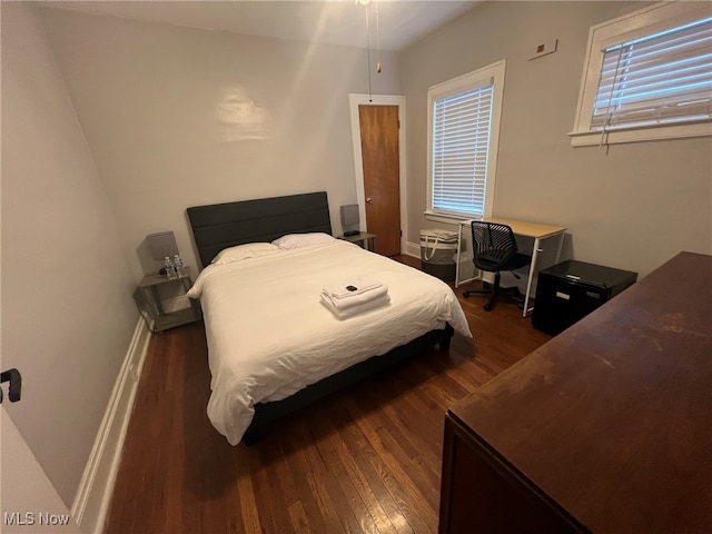 bedroom with dark wood-type flooring