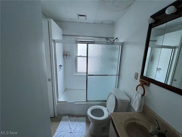 full bathroom featuring bath / shower combo with glass door, vanity, and toilet