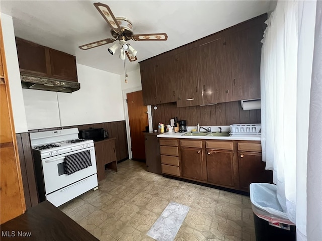 kitchen with dark brown cabinets, ceiling fan, sink, and white gas range oven