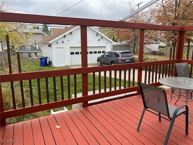 wooden terrace with a lawn and a garage