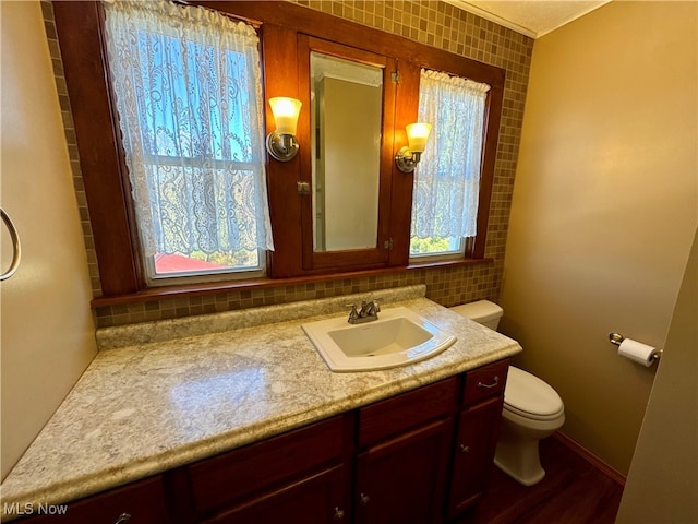 bathroom featuring wood-type flooring, vanity, and toilet