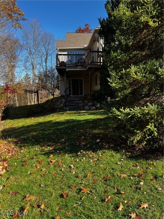 back of house with a deck and a lawn