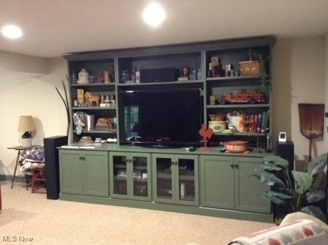 bar with green cabinets and light colored carpet