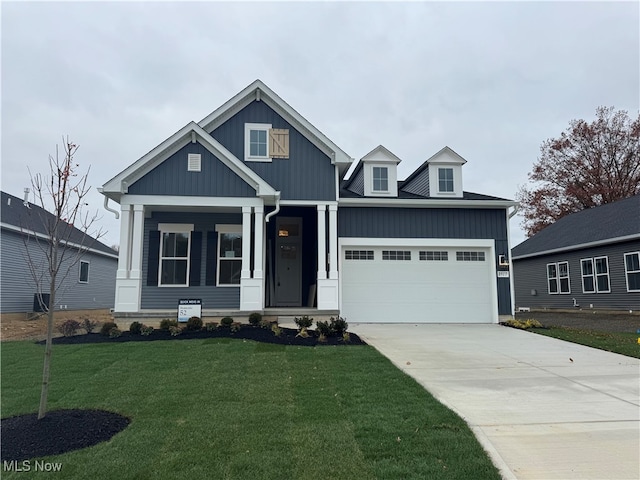 view of front facade with a garage, a porch, and a front lawn