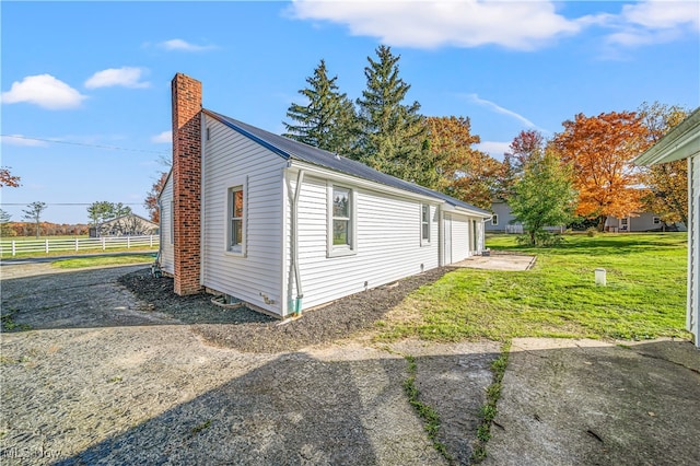 view of property exterior with a garage and a yard