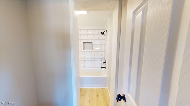 bathroom featuring tiled shower / bath combo and hardwood / wood-style flooring