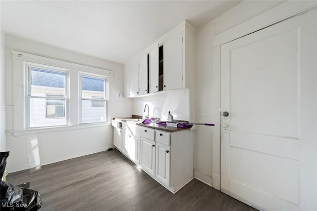 kitchen with white cabinets, dark wood-type flooring, and sink