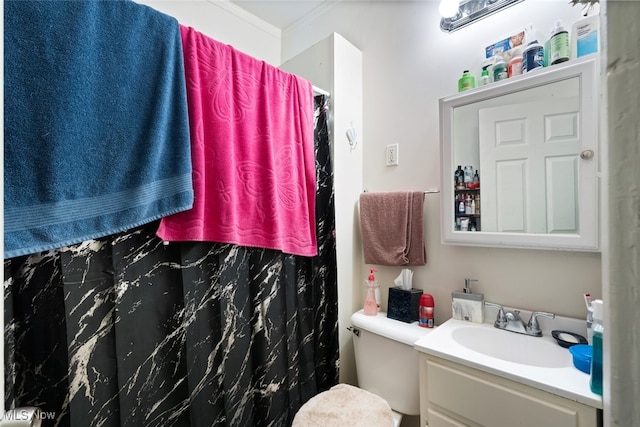 bathroom featuring toilet, vanity, curtained shower, and crown molding